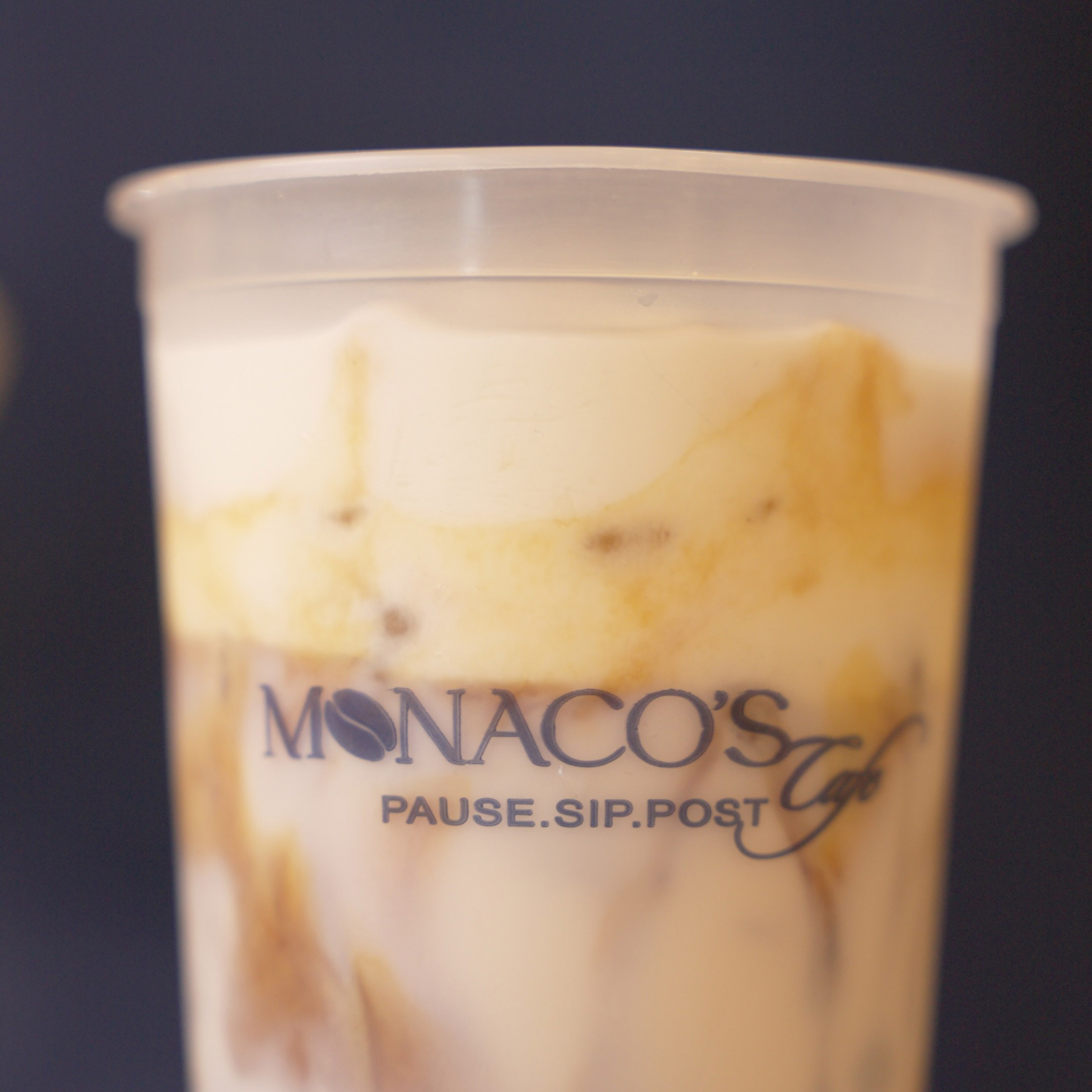 Iced latte in a Monaco's Cafe takeaway cup